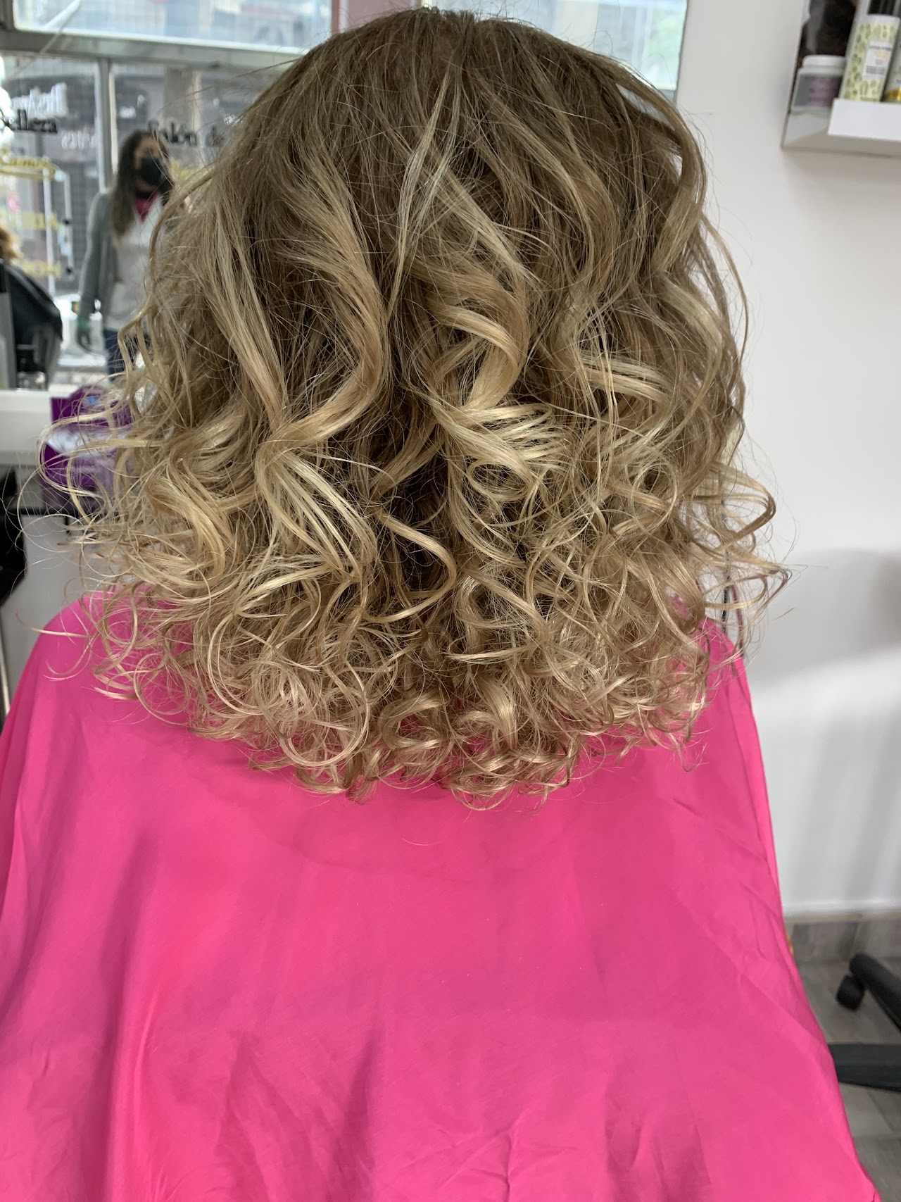 Portrait of a woman with stunning professional hair color, showcasing the high-quality services of Mónica Ramos Salon in a bright, luxury boutique environment. The lighting is soft and warm, reflecting the sophisticated and calming atmosphere of the Núñez neighborhood. The image has a premium, modern feel with a focus on hair health and shine.