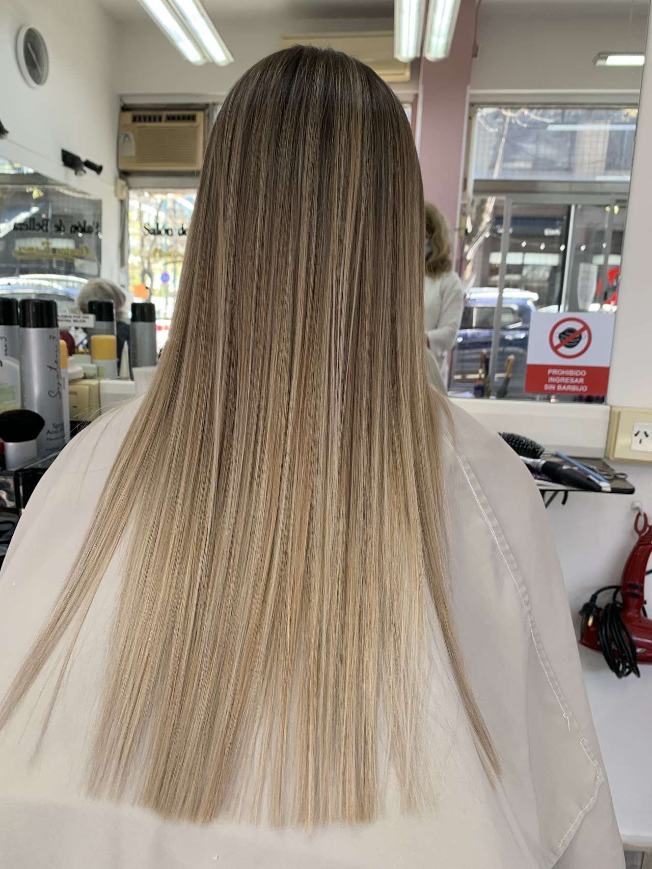 A vibrant and creative hair color design featuring shades of purple and electric blue on a sleek bob cut. The colors are perfectly blended, showcasing expert hair dyeing techniques in a modern salon setting with bright natural light.