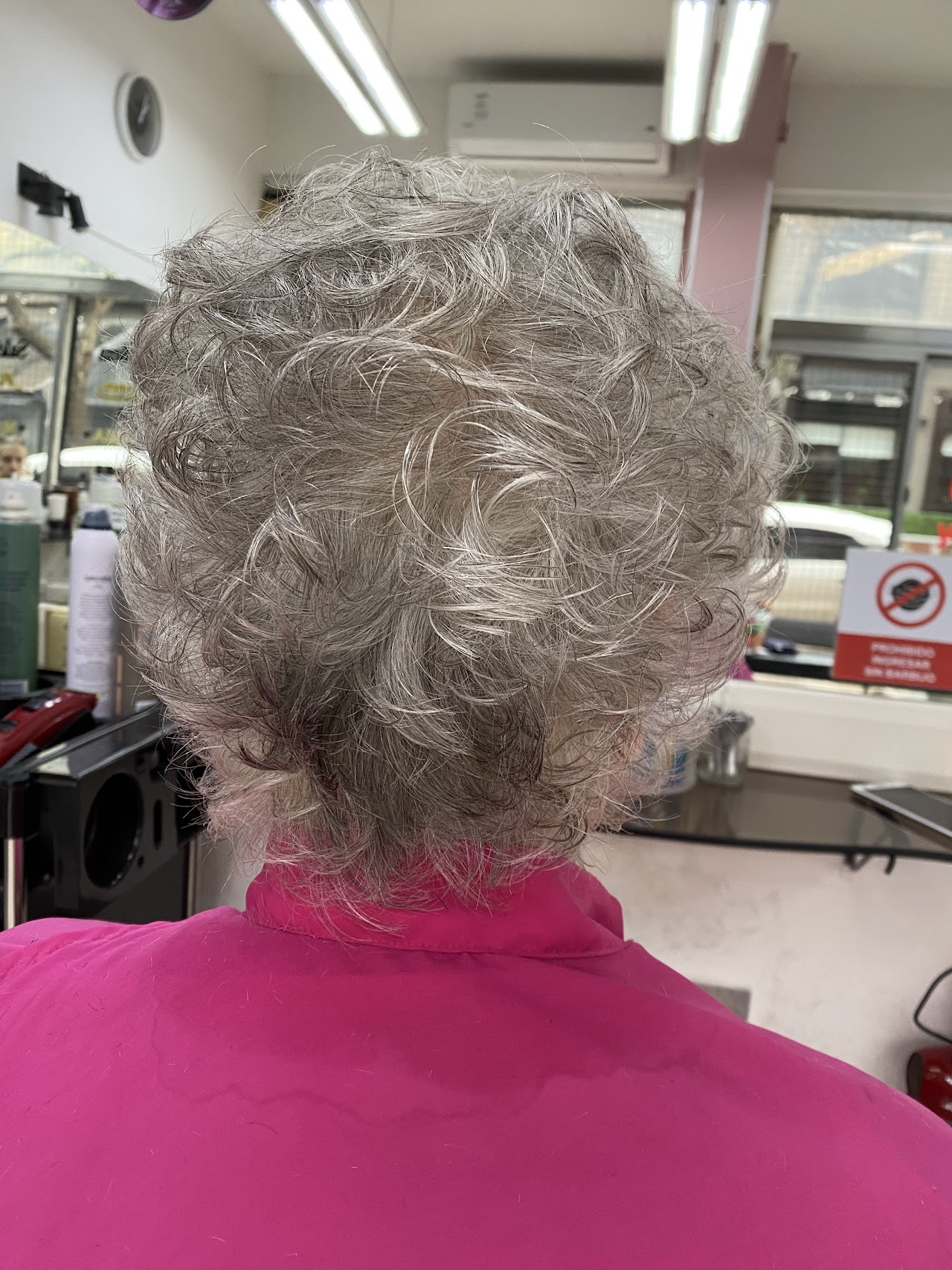 A precise and sophisticated asymmetrical bob haircut on a woman with dark hair. The cut is sharp and professional, demonstrating the high-end cutting skills available at Mónica Ramos salon. Minimalist lighting emphasizes the clean lines of the hairstyle.